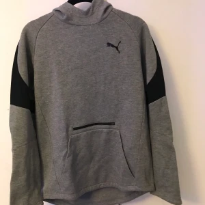 Grå Hoodie Puma - Snygg gråsvart hoodie från Puma. Säljer för att dne inte kommer till användning. Frakt tillkommer. 