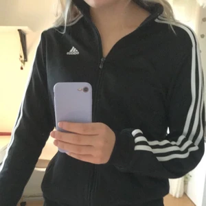 Adidas kofta - Svart adidas kofta. Jätte bra skick, säljer då jag har dubbla. Fickor med dragkedja. 80kr+frakt strl. 164, men passar mig som har S