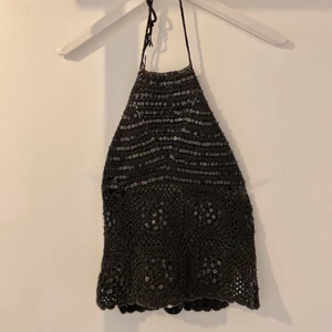 Svart virkad topp med öppen rygg  - Svart virkad topp. Ryggen är öppen och knyts med ett snöre.