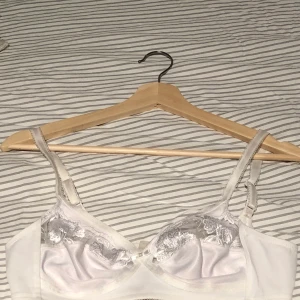 Triumph BH 75A - Superfin bh från Triumph med mesh/blommönster (se närbild) jättefin i kvalitén, ett riktigt kap! Använd en gång. OBS skriv bara om du verkligen tänker köpa.