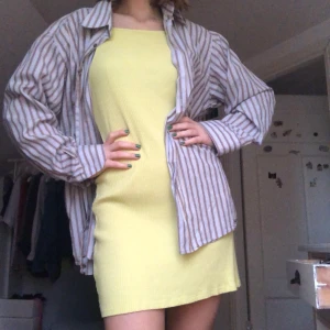 Klänning - Klänning från Weekday i ett ribbat material i en somrig, härlig,  ljusgul/grön färg. Jättesnygg med en t-shirt under eller skjorta över. Går till mitten av låren på mig som är 172 cm lång. Sparsamt använd. 80kr + frakt 