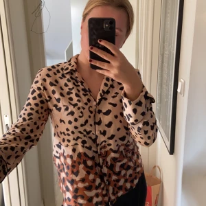 Skjorta  - En jättefin leopardmönstrad skjorta i lite glansigt tyg ifrån mango. Säljer då jag inte har någon användning för den.