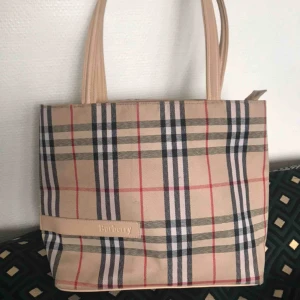  - En superfin Burberry-väska i mellanstorlek köpt second hand. Fint skick! Finns en liten tuschfläck på baksidan men det stör inte så mycket, har inte provat att tvätta bort den så det kanske går. Älskar väskan men en fattig student behöver pengar 😭