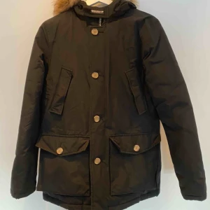  - Säljer en svart parkasjacka från Woolrich. Det är barnmodell, i storlek 14 år men går att likställa som en XS/S. Den är sparsamt använd, en perfekt vinterjacka!☺️