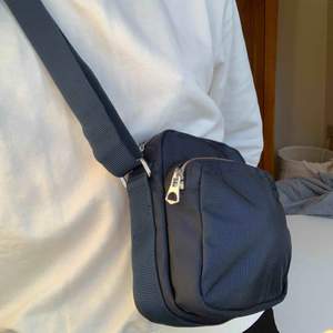 Nyinköpt marinblå väska från Weekday med reglerbart axelband. Riktigt rymlig trots att den ser så liten ut.   Kan mötas i Stockholm annars tillkommer frakt på 40kr :)