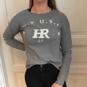  - Fin grå collegetröja men stjärnor på armbågarna. Passar upp till en S/M