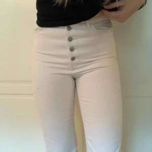  - Vita croppade byxor med 5 knappar. Använda cirka 5 gånger. Finns inga fläckar men dem har ej lyckats behålla den kritvita färgen som när man precis köpt dem. Storlek 38 men sitter ganska tajt. Mycket croppade som ni kan se på andra bilden. 