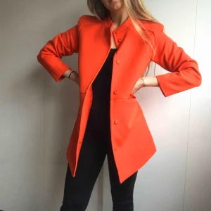 Kappa - Supersnygg brandröd kappa från H&M.  Ingen dragkedja utan man knäpper igen den.   Har fler bilder på hur jackan ser ut om någon är intresserad av kappan.   Köparen betalar för eventuell portokostnad. 