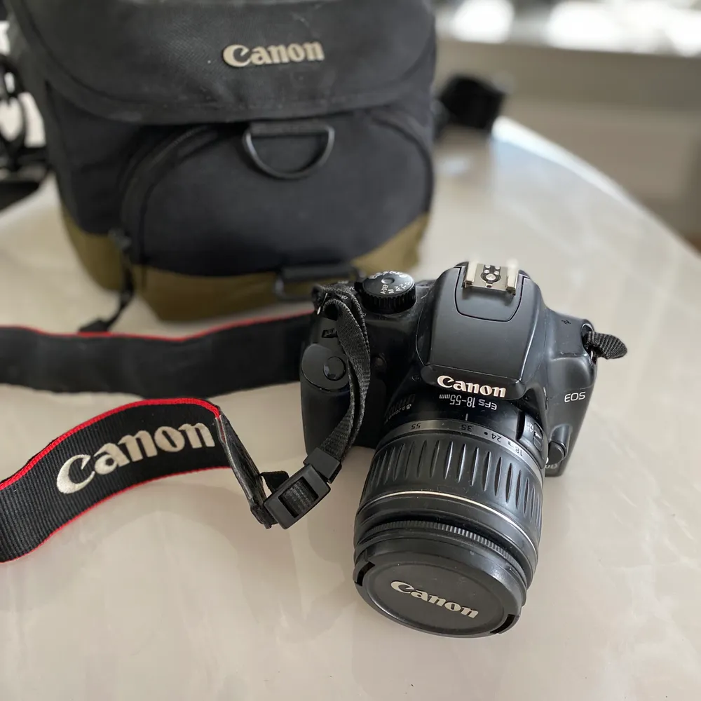 Canon EOS 1000D systemkamera i bra skick. Ingår även laddare till batteriet och en kameraväska.. Övrigt.