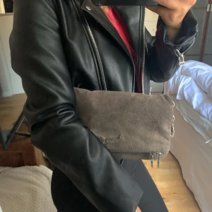 Zadig Voltaire väska  - Säljer nu min älskade Zadig väska i grå mocka då den tyvärr inte längre kommer till användning, köpt för 2900kr, priset är på 1300kr då mockan är lite sliten 