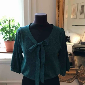  - Blå glittrig topp med puffärm och rosett framtill! Har använt den både på rätt håll men även bakofram vilket jag också tycker är superfint (se bild 3)! Storlekslappen är borta men skulle säga att den är en strl S! Jättebra skick 💗