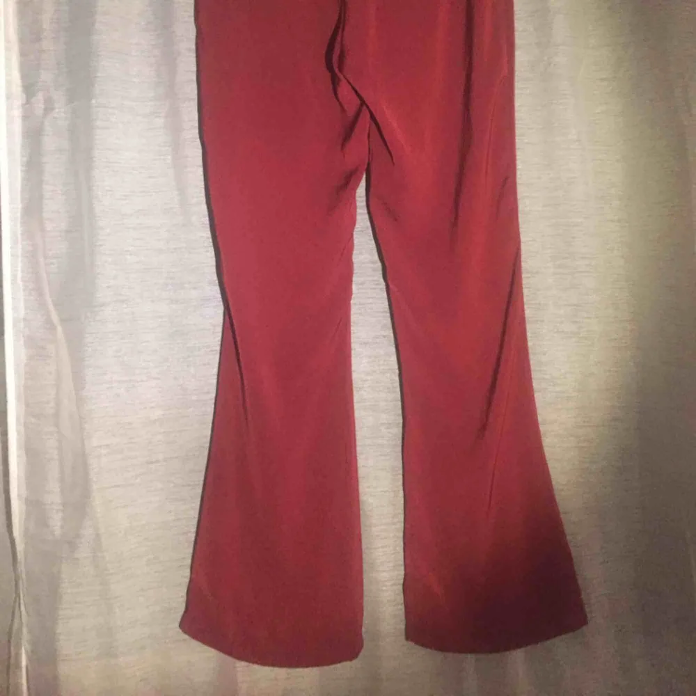 Röda finare byxor med fickor fram, rena bak, något utsvängda. Passar M-L (mindre L). Jeans & Byxor.