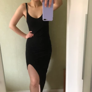 Svart slitsklänning från bikbok - En stretchig slitsklänning från bikbok. Klänningen är väldigt figurnära  och består av ett skönt material. Använd 1 gång.  🦋Fraktkostnad tillkommer🦋