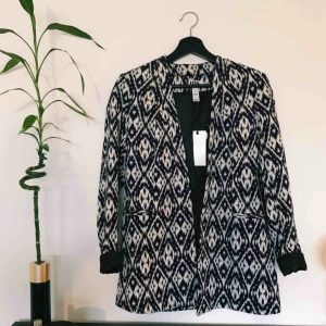  - Mönstrad kavaj i mörkblått och vitt. Oanvänd, prislapp fortfarande kvar. Frakt på 72 kr tillkommer. 