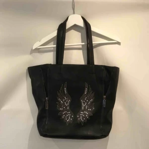  - Cool väska i skinnimitation från märket Eternel. Har små stenar på framsidan och 4 dragkedjor som går att justera beroende på vilken form du vill ha på väskan. Möts upp i Stockholm eller så står köpare för frakt, tar swish!