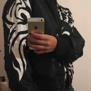  - Reversibel bomber jacka. Kan vara både svart och mönstrad som på bilden :)