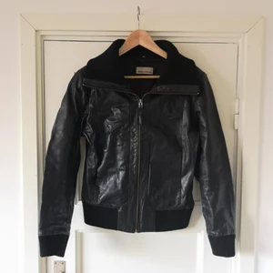 Rock'n'Blue Läderjacka strl 40 - Svart skinnjacka i äkta läder med dragkedja. Muddar och stor krage i mjuk varm polyester och innerfoder i silkestyg. Jackan är hyfsat nyligen infettad så det är mjuk och skön. Väldigt fint skick och väl omhändertagen 🍁🍂  nypris 2000 kr ish