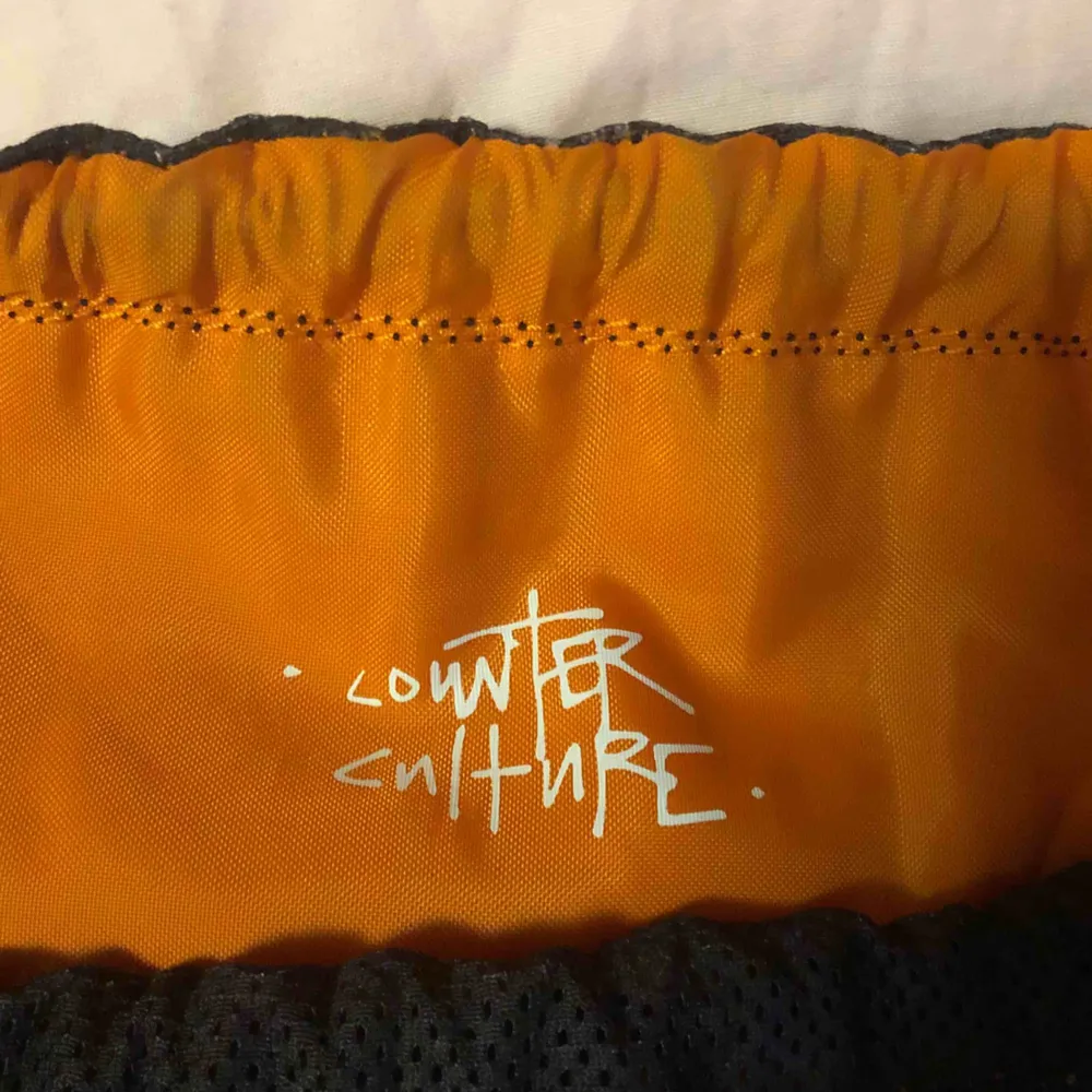 Counter Culture // Mo'Wax x Nike Fin ryggsäck i svart mesh med oranget tyg under.    . Väskor.