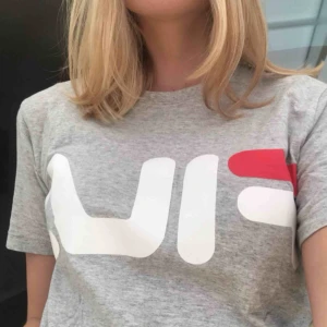  - Grå Fila t-shirt i bra skick, köpt på Junkyard för 299kr. Använd ett fåtal gånger. Passar nog även en M men då blir passformen tightare. Fraktar gärna.   Har även en likadan fast i rosa