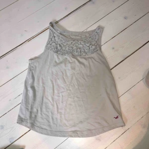  - Litet ljugrått linne från Hollister, spets upptill och små blommor (allt ljusgrått). Några år gammalt men inga hål, slitningar eller liknande. Väldigt gulligt, nypris ungefär 500 kr