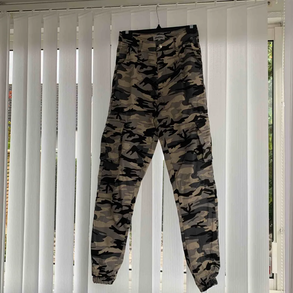 Beigea camo cargobyxor med bra passform och fickor på sidorna och muddar på byxbenen. Jeans & Byxor.