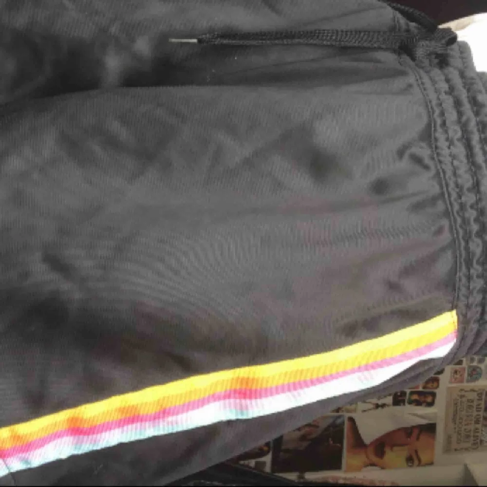 Svarta mjukis shorts med regnbågsmönster på sidan, använd CA 2 gånger och köpt för 50kr. Shorts.