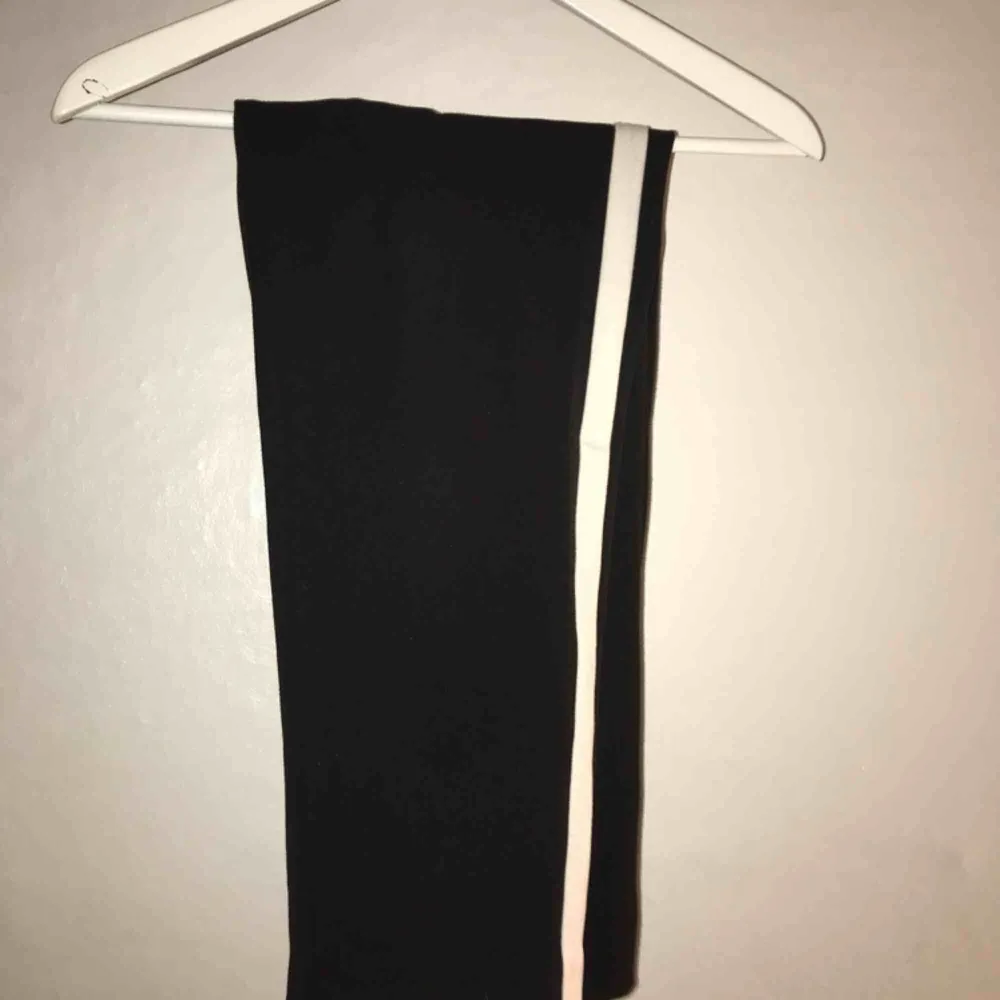 Svarta kostymbyxor med vit rand på benet från Zara. Kort i modellen. Använda typ 4 gånger, sälja pga används ej . Jeans & Byxor.