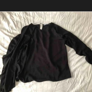  - Blus med volang på ärmarna