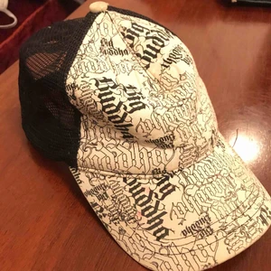  - Keps. Snygg passform. Nät i baksidan.  Text och mönster.  Några fläckar av färg. 