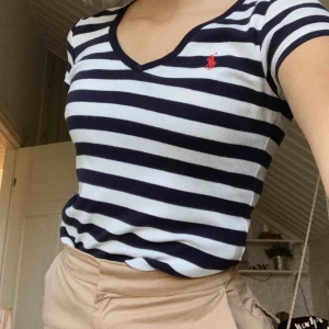  - Blå-vit randig t-shirt med v-ringning från Ralph Lauren. Kommer aldrig till användning längre, därav säljer jag den. Tröjan är sparsamt använd och köparen står för frakten. Kontakta mig vid övriga frågor! :)