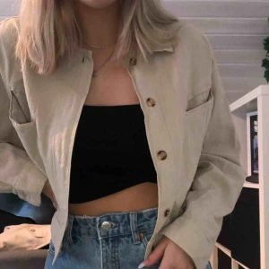  - Beige croppad jacka.