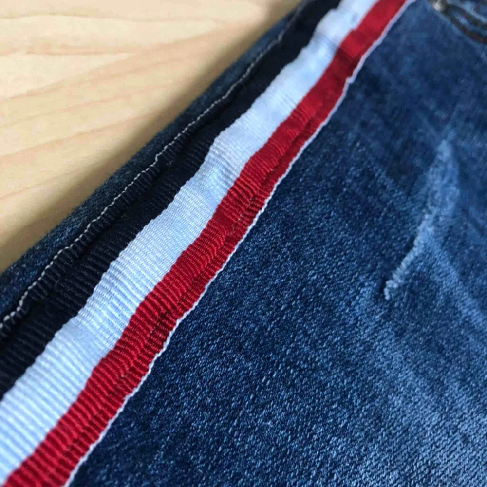 Skit snygga jeans med en röd, vit och blå revär längs med sidan. Använt fåtal gånger så är fortfarande i nyskick.. Jeans & Byxor.