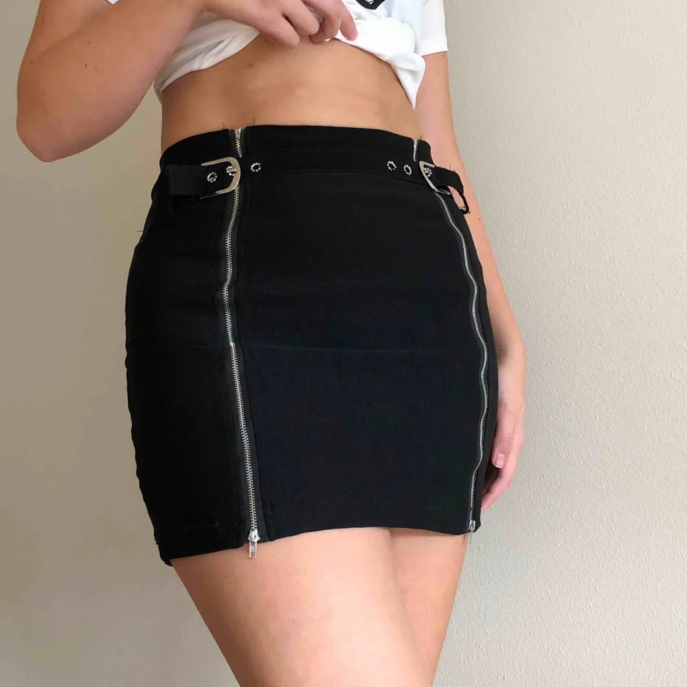 kort svart kjol med dragkedja och spänne, töjbar, knappt använd, köpt från Shein  Storlek M midja: 72 höst storlek: 90 längd: 42. Kjolar.