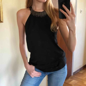  - Svart ”festtopp” i storlek 38/M från HM. Runt halsen har den små prynadspälor som hänger, sen knyter man den i nacken i en rosett som syns i sista bilden. Säljer pga att jag aldrig använt den! Möts upp i Stockholm, skriv vid intresse eller mer info!😁