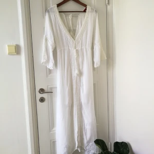  - Vacker vit klänning, V-ringning fram och bak. Använd två ggr. Miniminifläck som kan ses på tredje bilden. 