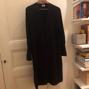  - Svart långärmad klänning / tunika från Weekday. I skirt material, fin till jeans eller bara som klänning. Knäpps framtill samt slitsar på sidorna. Kan skickas mot fraktkostnad eller mötas upp i Stockholm. 