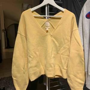 Säljer en gul v-ringad stickad tröja från HM i ull. Orginalpris 499kr. Använd 2 gånger.