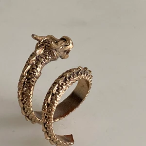 Guldig drak ring - Säljer denna ring för den inte kmr till andvändning. Den kommer från Gina och är i storlek M eller S. Svansen har råkat åka av annars är den i topp. Man kan få svansen med oxå så kan man ksk fixa den. Buda! Säljer vid bra pris. Köparen står för frakten😊🦋