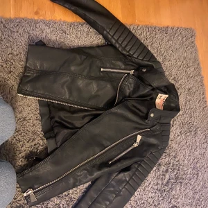 Chiquelle skinn jacka  - Säljer min skin jacka från chiquelle för jag har ingen anvöndning för den. Den är storlek Xs. Men på baksidan har den en liten skråma som ni ser på sista bilden, syns knappt men bra att veta😊