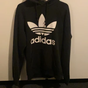 Adidas hoodie - Säljer denna fina svarta adidas hoodien! Sen är välanvänd men i fint skick! Det ena snöret har fluffat sig men inget annat märkbart! Säljer för: 50kr+frakt! Om fler blir intresserade så blir det budgivning