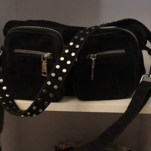 Celina svart är en av Noellas populäraste modeller av Crossover väska i svart med rem som har två rader med nitar. Denna crossover-väska kan även bäras som en Crossbody-väska. Den är använd några gånger fast den är ändå hyfsat ny. Den kostar egentligen 700 kronor  