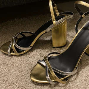 Högklackat  - Använda ca 2-3 gr. Guldiga skor med silvriga detaljer 