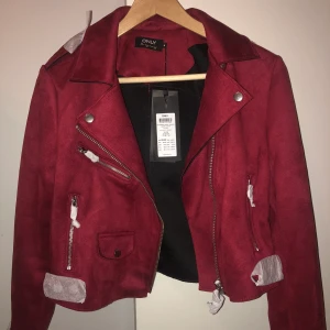 Bikerjacket röd - I mockaimitation. Aldrig använd! Beställde när jag var utomlands och var för sent för retur när jag kom hem. Strl 36 nypris 629kr. 