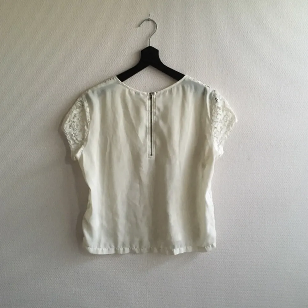 Något kortare t-shirt i spets från H&M. Genomskinligt material i ryggen samt en dragkedja. Passar XS/S. 

Fraktar eller möts upp i Stockholm/norrort.. T-shirts.
