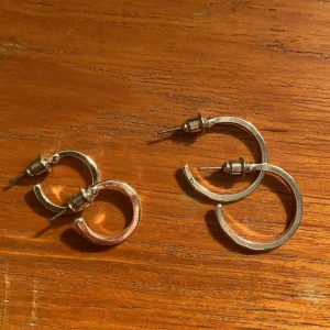 Två-pack örhängen (ringar) - Säljer dessa två örhängena som aldrig använts, dem är i olika storlekar. De största är 2 cm på diametern och de små i ca 1,5 cm på diametern. Ett par för 25kr och båda för 40kr. Köparen står för frakten❤️ hör av er vid frågor eller om ni vill ha fler bilder.