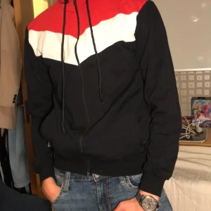 Zip-hoodie - Har burits av en legendarisk Pokémon-tränare. Bekräftad fakta. Som flaggan av Angola: Röd, vit och svart.