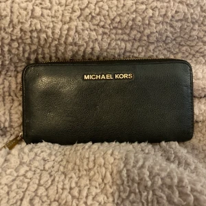 Michael Kors Plånbok  - Michel Kors plånbok i använt skick. Se bilder på vart den är sliten. Plats för 8 kort och myntfack.