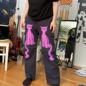 Målade byxor i M - Hej! Jag säljer ett par gamla byxor jag har målat! De har rosa katter på, och man kan göra dem även till shorts! De är oversized, men lågmidjade. Då jag oftast gillar högmidjade sitter dessa ändå bra. Det är även rak form. Skriv till mig för mer detaljer!
