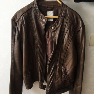  - Bikerjacka i skinnimitation storlek 40. Mycket fint skick! jag är en 36a men har kört denna oversize vilket är snyggt! 