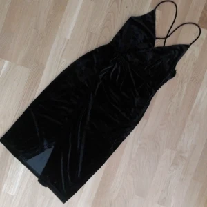  - Svart klänning i sammet med slits fram och djup rygg. Från Madlady, oanvänd med lappen kvar. Kan mötas upp i Linköping, annars står köparen för frakt.
